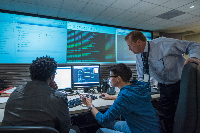 Colleagues working together in server control room