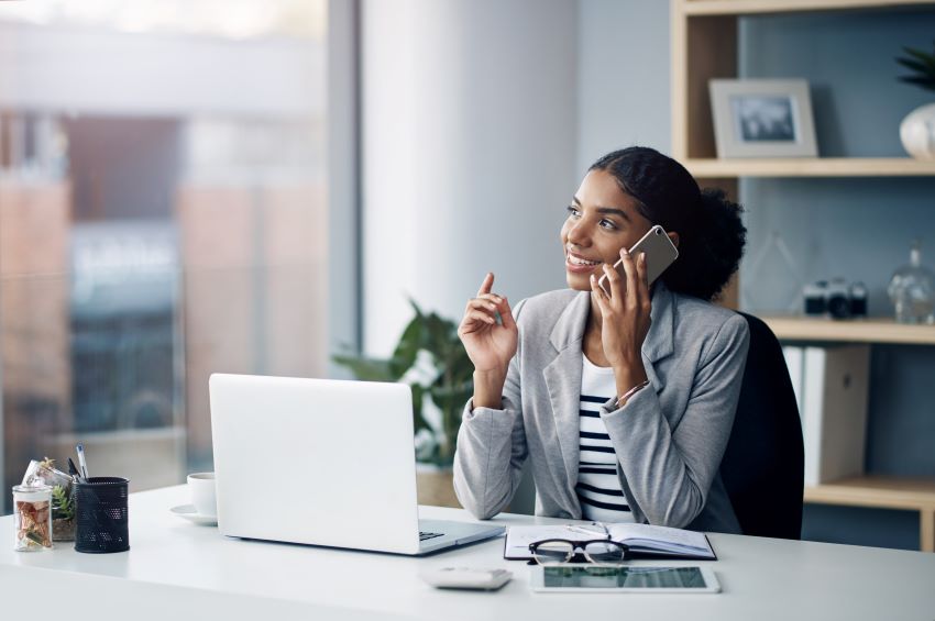 woman sitting at home office on the phone