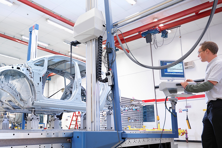 Factory worker at workstation in automobile factory