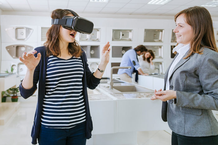 Woman in a home remodeling store using a VR headset to view kitchen products