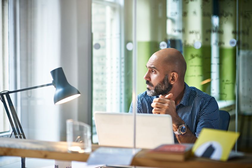 man at laptop looking out the window