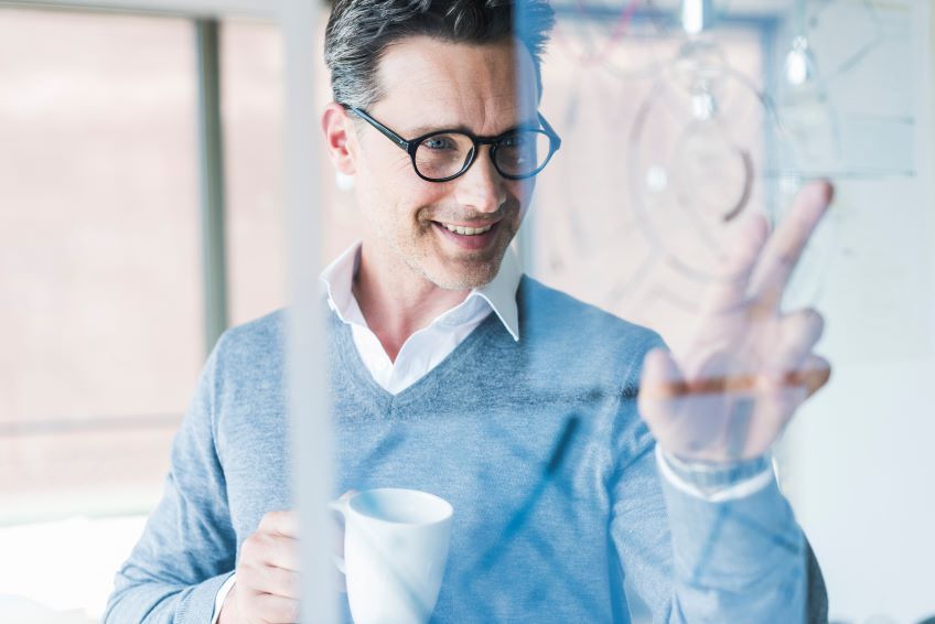 man uses clear screen to review metrics