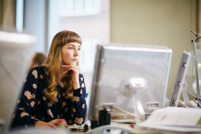 woman concentrating on her desktop computer