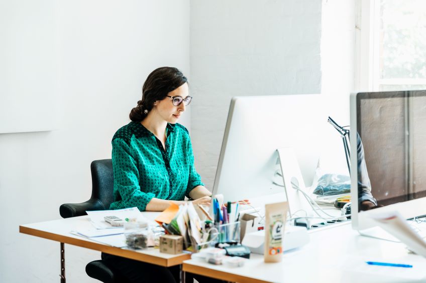 Woman working at desk on computer