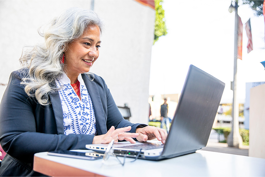 Woman working on a laptop from a remote location