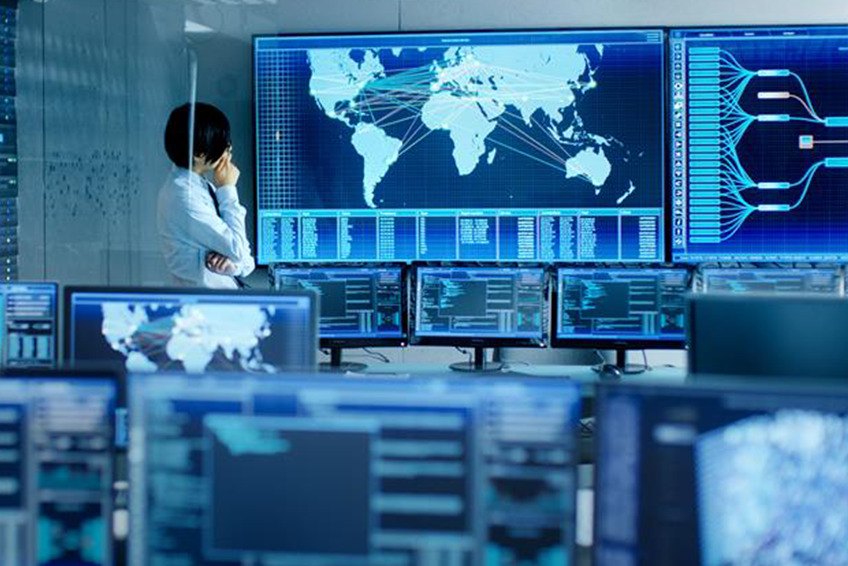 Man stands at control center screen, looking at a map.